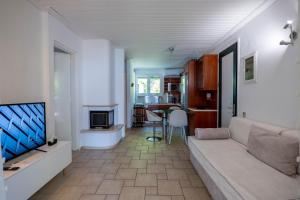a living room with a couch and a flat screen tv at Corfu Glyfada Beach Apartment 13 in Glyfada
