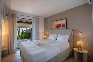 a bedroom with a large white bed with a window at Corfu Glyfada Beach Apartment 13 in Glyfada