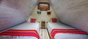 two beds in a small room with at Hay & Mountain Huts in Colcapampa