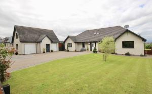 a house with a lawn in front of it at BROHAR ANNEXE detached apartment with exceptional views and EVcharger in Inverness +21 photos