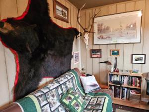 a statue of a bear on the wall next to a couch at Hidden Creek Cabin in Beaverlodge