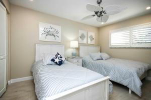 a bedroom with two beds and a ceiling fan at Sanibel Arms West Unit A1 in Sanibel +17 photos