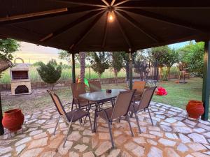 a table and chairs under an umbrella on a patio at Villa Emara Mangana in Mángana