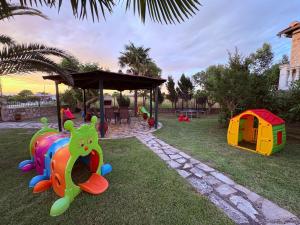 a playground with a toy train on the grass at Villa Emara Mangana in Mángana +54 photos