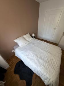 a bedroom with a bed with white sheets and pillows at LebonCosy in Limoges +2 photos