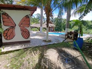 a butterfly mural on the side of a house at Quinta Gualca in Condega