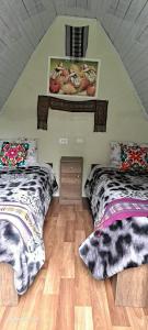 a room with two beds in a attic at Hay & Mountain Huts in Colcapampa +6 photos