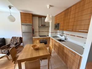 a kitchen with wooden cabinets and a wooden table at Cozy apartment with mountain views in Panticosa