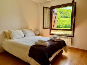 a bedroom with a bed and a window with towels on it at Cozy apartment with mountain views in Panticosa