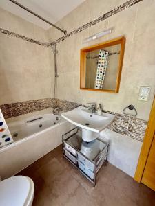 a bathroom with a sink and a tub and a toilet at Cozy apartment with mountain views in Panticosa +17 photos