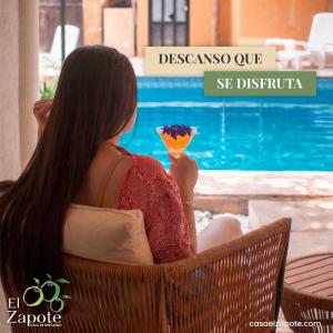 a woman sitting in a chair holding a drink at El Zapote Casa de Descanso in Malinalco
