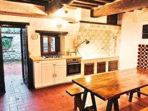 a large kitchen with a wooden table and a wooden table sidx sidx sidx at Tudesia Charming house in Todi