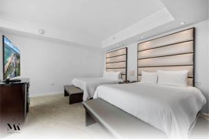 a bedroom with two beds and a flat screen tv at Fontainebleau 2Dbl Queen Bed City plus Ocean View in Miami Beach