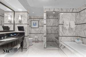 a bathroom with a tub and a toilet and a sink at Fontainebleau 2Dbl Queen Bed City plus Ocean View in Miami Beach +12 photos