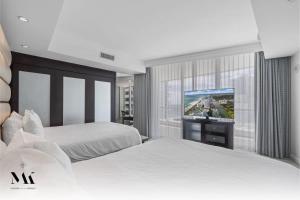 a hotel room with two beds and a flat screen tv at Fontainebleau 2Dbl Queen Bed City plus Ocean View in Miami Beach