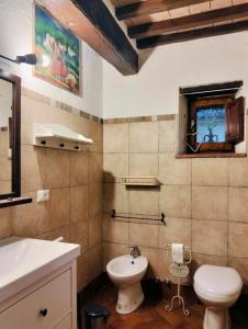 a bathroom with a white toilet and a sink at Tudesia Charming house in Todi +28 photos
