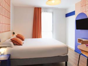 a bedroom with a large white bed and a window at Aparthotel Adagio Access Rennes Centre in Rennes +47 photos