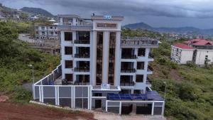 a large white building with a balcony on a hill at K&K Luxurious Landing in Limbe
