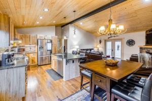 a large kitchen with a wooden ceiling and a table at Little Bear in Maggie Valley