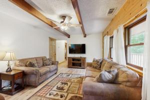 a living room with two couches and a flat screen tv at Hollow's End in Whittier
