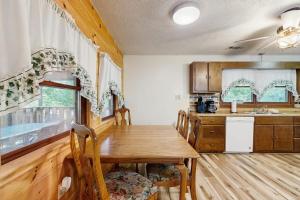 a kitchen with a wooden table with chairs and a sink at Hollow's End in Whittier
