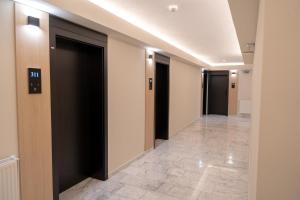 a hallway with black doors and tile floors at Piscul Negru Hotel - Transfagarasan in Cumpăna