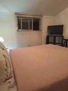 a bedroom with a bed and a flat screen tv at House Heart in Amora