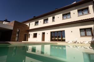 a house with a swimming pool in front of it at Alojamiento ENSUEÑOS in Ciudad-Rodrigo