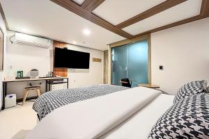a bedroom with a bed and a desk and a television at Ramon Hotel in Seoul