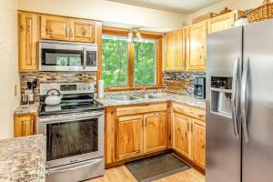 a kitchen with wooden cabinets and stainless steel appliances at Grin and Bear It in Whittier