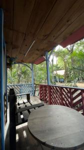a wooden table and benches on a deck with a table and umbrella at Cabañas El paso Tulum in Chemuyil