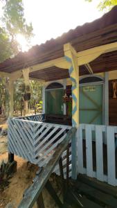a house with a porch with a fence at Cabañas El paso Tulum in Chemuyil
