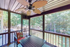 a screened in porch with a ceiling fan and a bench at The Marlin in Arden
