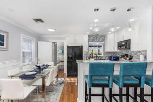 a kitchen with white cabinets and blue bar chairs at Naples Luxury 5BDRM HomeHtd PoolSuperCleanPets in Naples