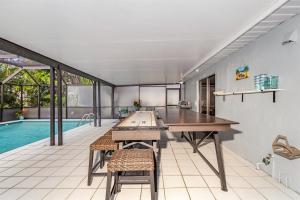a room with a pool and a table and chairs at Naples Luxury 5BDRM HomeHtd PoolSuperCleanPets in Naples