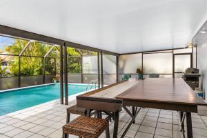 a dining room with a ping pong table and a swimming pool at Naples Luxury 5BDRM HomeHtd PoolSuperCleanPets in Naples +39 photos