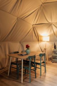 a table and chairs in a tent at Manteiros Glamping in Canas de Senhorim
