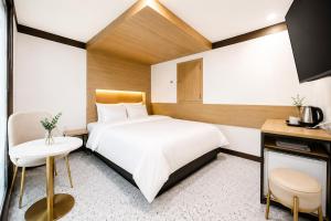 a hotel room with a large bed and a desk at Ramon Hotel in Seoul