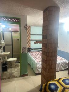 a room with a bedroom with a bed and a sink at Hotel Atenas in Jericó
