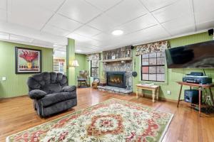 a living room with a chair and a fireplace at Hidden Creek Cabin in Franklin