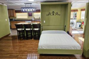 a bedroom with a bed and a kitchen with a table at Hidden Creek Cabin in Franklin