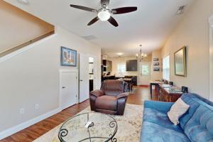 a living room with a blue couch and a ceiling fan at Cool Springs Manor in Asheville