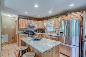 a kitchen with wooden cabinets and a stainless steel refrigerator at Oasis In the Mountains in Murphy