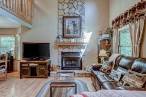 a living room with a leather couch and a fireplace at Oasis In the Mountains in Murphy