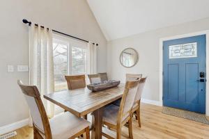 a dining room with a wooden table and chairs and a blue door at Wildwood in Fletcher