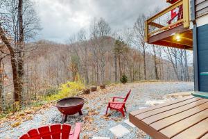 a grill and chairs on a porch of a house at Bryson Chalet in Bryson City