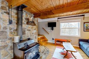 a living room with a stone fireplace and a couch at Bryson Chalet in Bryson City +18 photos