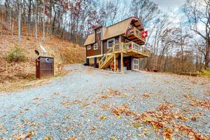 a house on a hill with a gravel driveway at Bryson Chalet in Bryson City