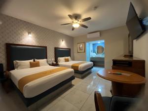 a hotel room with two beds and a television at Hotel Maioris Bellavista in Culiacán