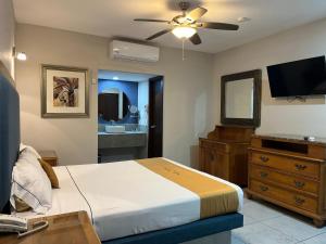 a bedroom with a bed and a television and a dresser at Hotel Maioris Bellavista in Culiacán